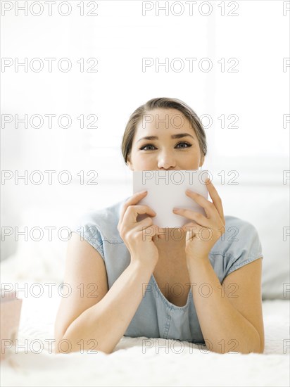 Woman holding envelope on bed