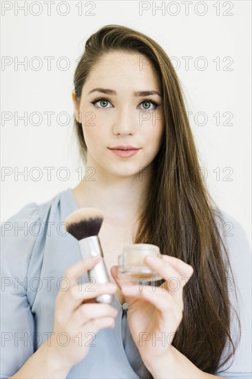 Woman holding powder and make up brush