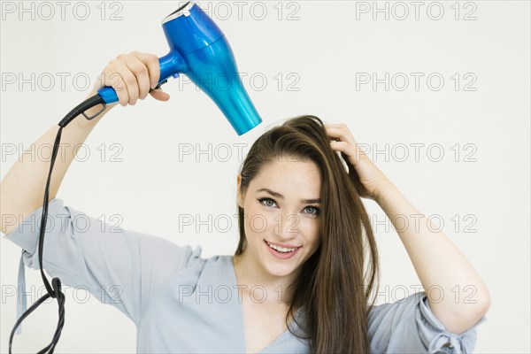 Woman using hair dryer