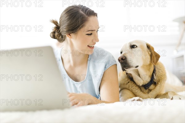 Woman using laptop with dog