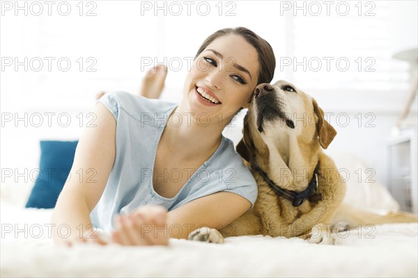 Woman lying on bed with dog