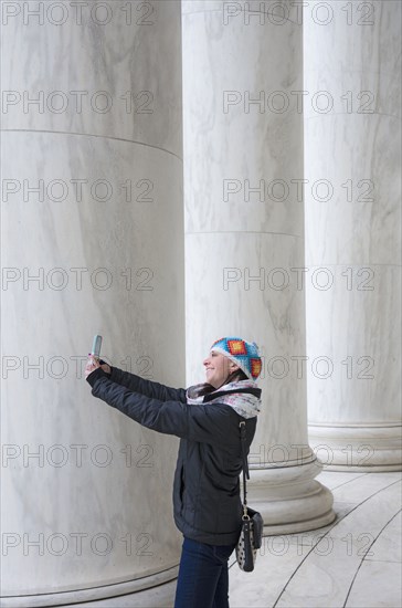 Woman taking selfie by pillars