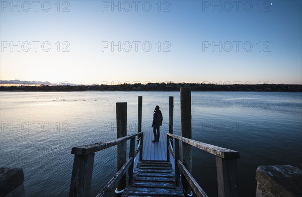 Man standing on pier at dawn