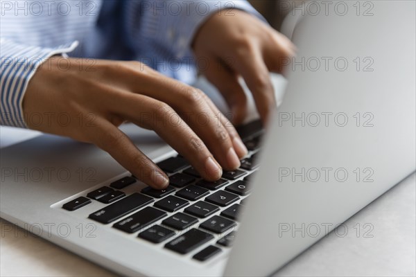 Hands of woman typing on laptop