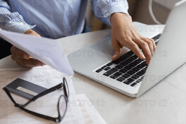 Hands of woman typing on laptop