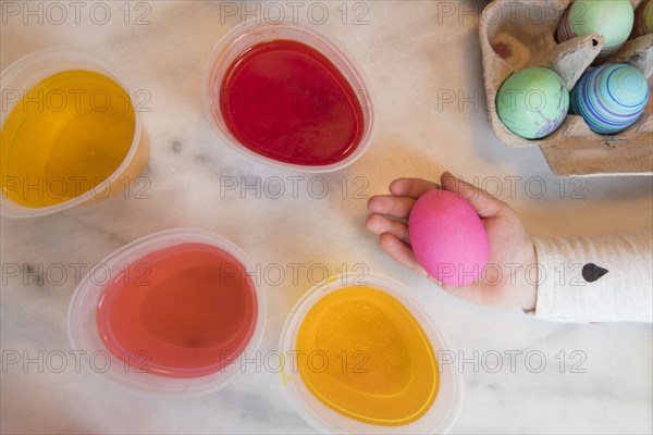 Hand of girl holding pink Easter egg