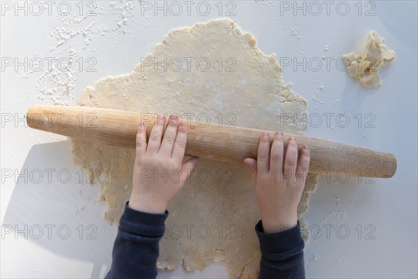 Boy's hands rolling dough