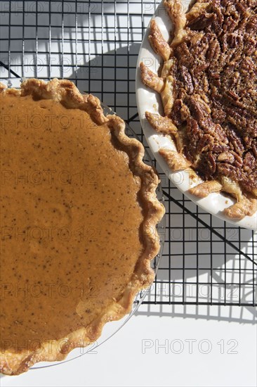 Pumpkin and pecan pies on a cooling rack