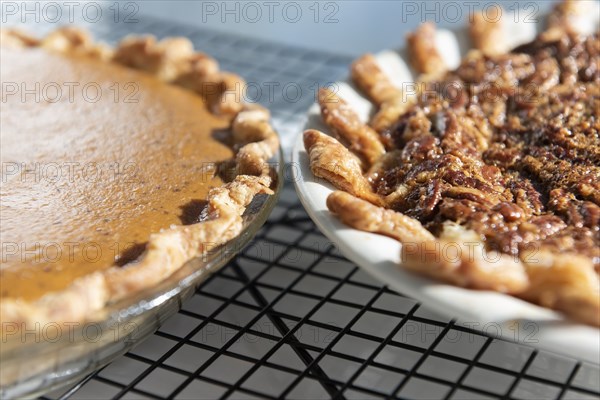 Pumpkin and pecan pies on a cooling rack