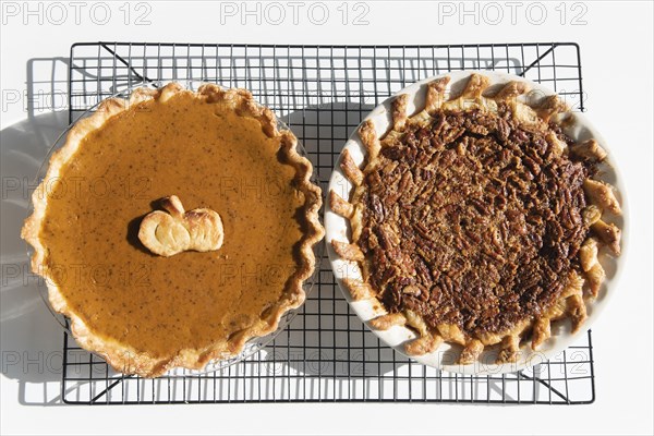 Pumpkin and pecan pies on a cooling rack