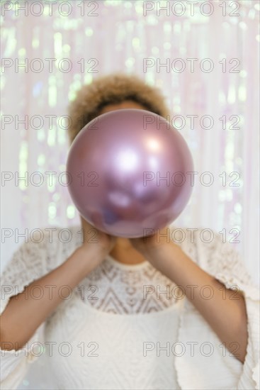 Young woman inflating balloon