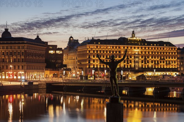 Statue by buildings at sunset in Stockholm, Sweden