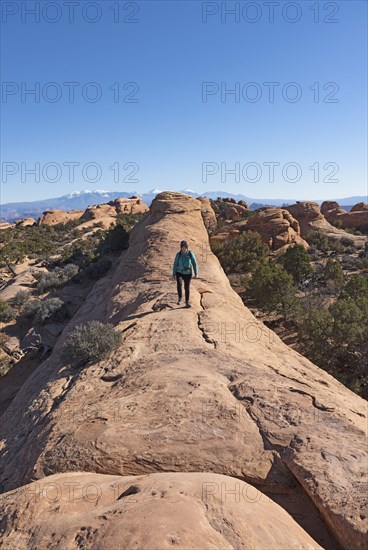 Woman hiking on rock in Arches National Park, Utah, USA