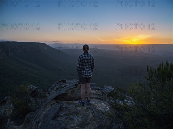 Woman standing on peak of Blue Mountains at sunrise in New South Wales, Australia