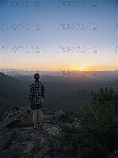 Woman standing on peak of Blue Mountains at sunrise in New South Wales, Australia