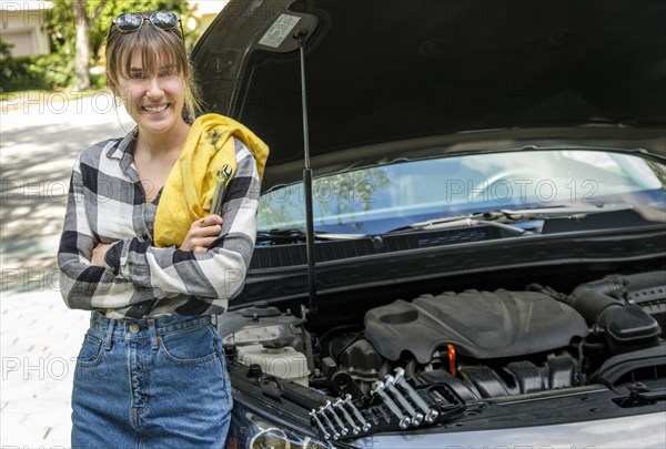 Woman with oil rag beside car