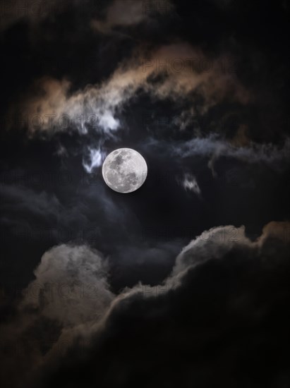 Full moon among clouds