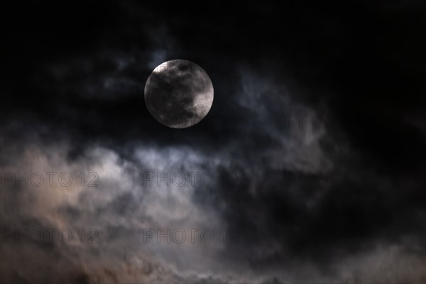 Full moon among clouds