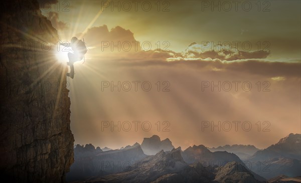 Silhouette of woman rock climbing in the Dolomites at sunrise