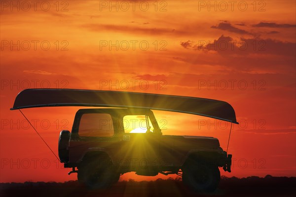 Canoe on top of Jeep at sunset