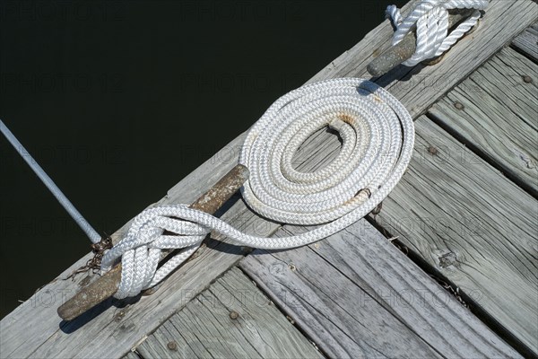 Coiled rope tied to mooring on pier