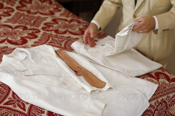 Man folding vintage white suit