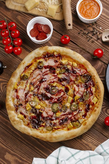 Pizza and ingredients on wooden table