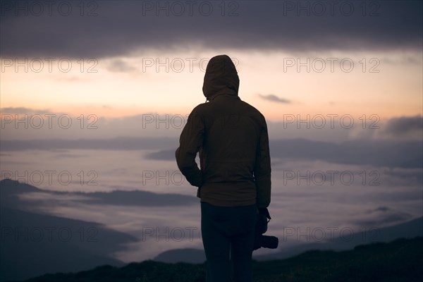 Silhouette of young man with camera at sunset in the Carpathian Mountain Range