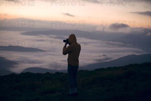 Silhouette of young man taking photographs at sunset in the Carpathian Mountain Range