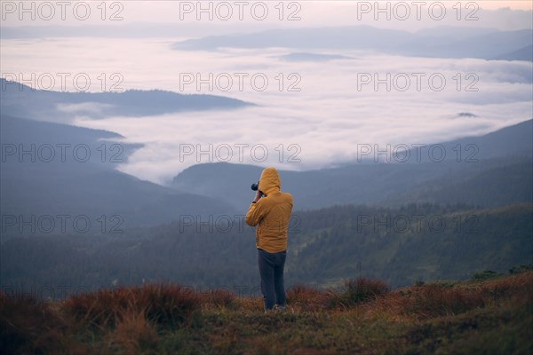 Man in yellow jacket taking photographs in the Carpathian Mountain Range