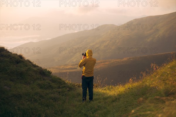 Man in yellow jacket taking photographs in the Carpathian Mountain Range