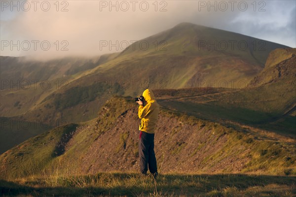 Man in yellow jacket taking photographs in the Carpathian Mountain Range