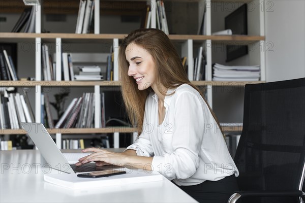 Smiling businesswoman working on laptop