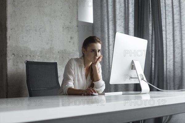 Frustrated businesswoman working at desktop computer