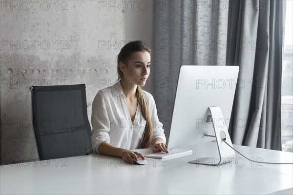 Young businesswoman working on desktop computer