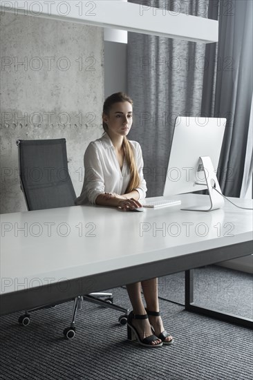 Young businesswoman working on desktop computer