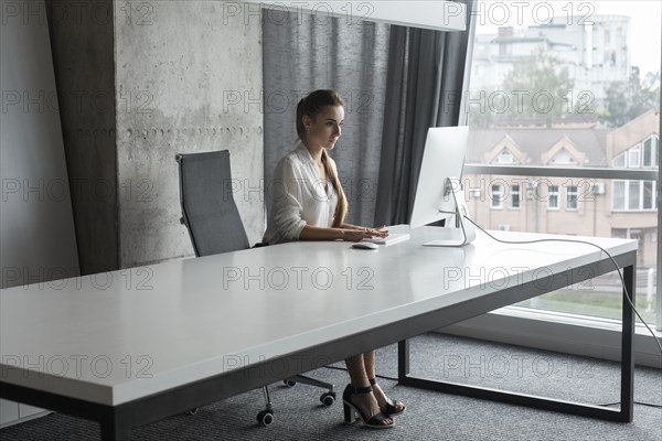 Young businesswoman working on desktop computer