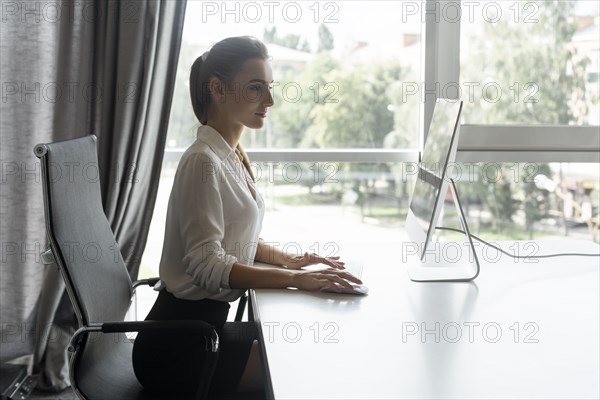 Young businesswoman working on desktop computer