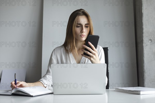 Young businesswoman looking at smartphone