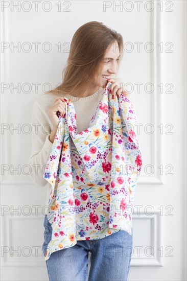 Smiling woman holding floral pattern fabric