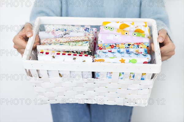 Woman's hands holding basket of fabrics