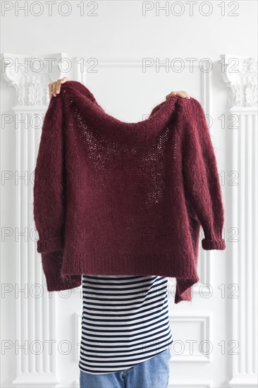 Woman holding maroon wool sweater