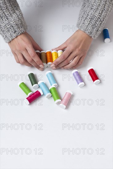 Woman's hands organizing colorful spools of thread