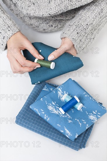 Woman's hand matching thread to blue fabric