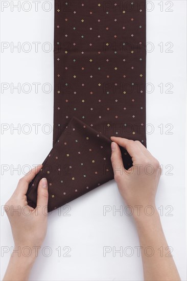 Hands of woman folding brown fabric