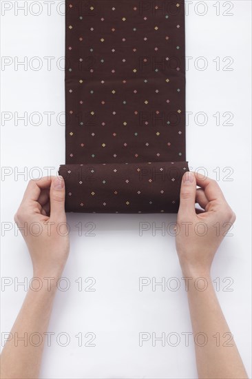 Hands of woman folding brown fabric