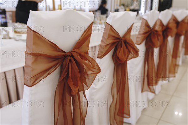 Ribbon tied to dining chairs at wedding