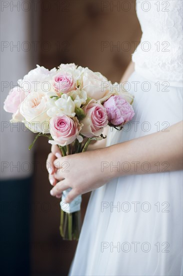 Hands of bride holding bouquet