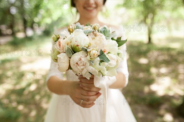 Bride holding bouquet of roses