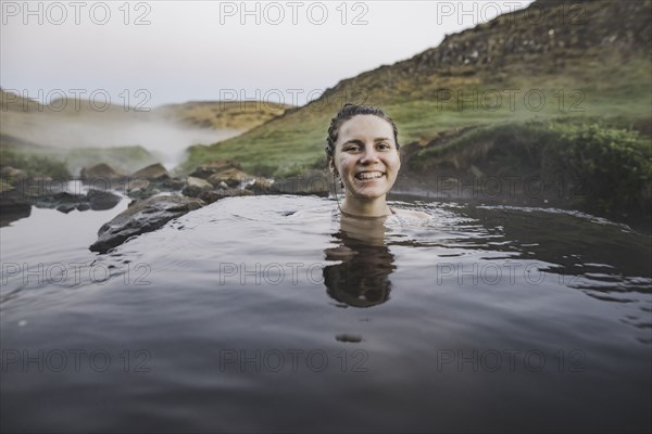 Woman bathing in hotpool in Iceland